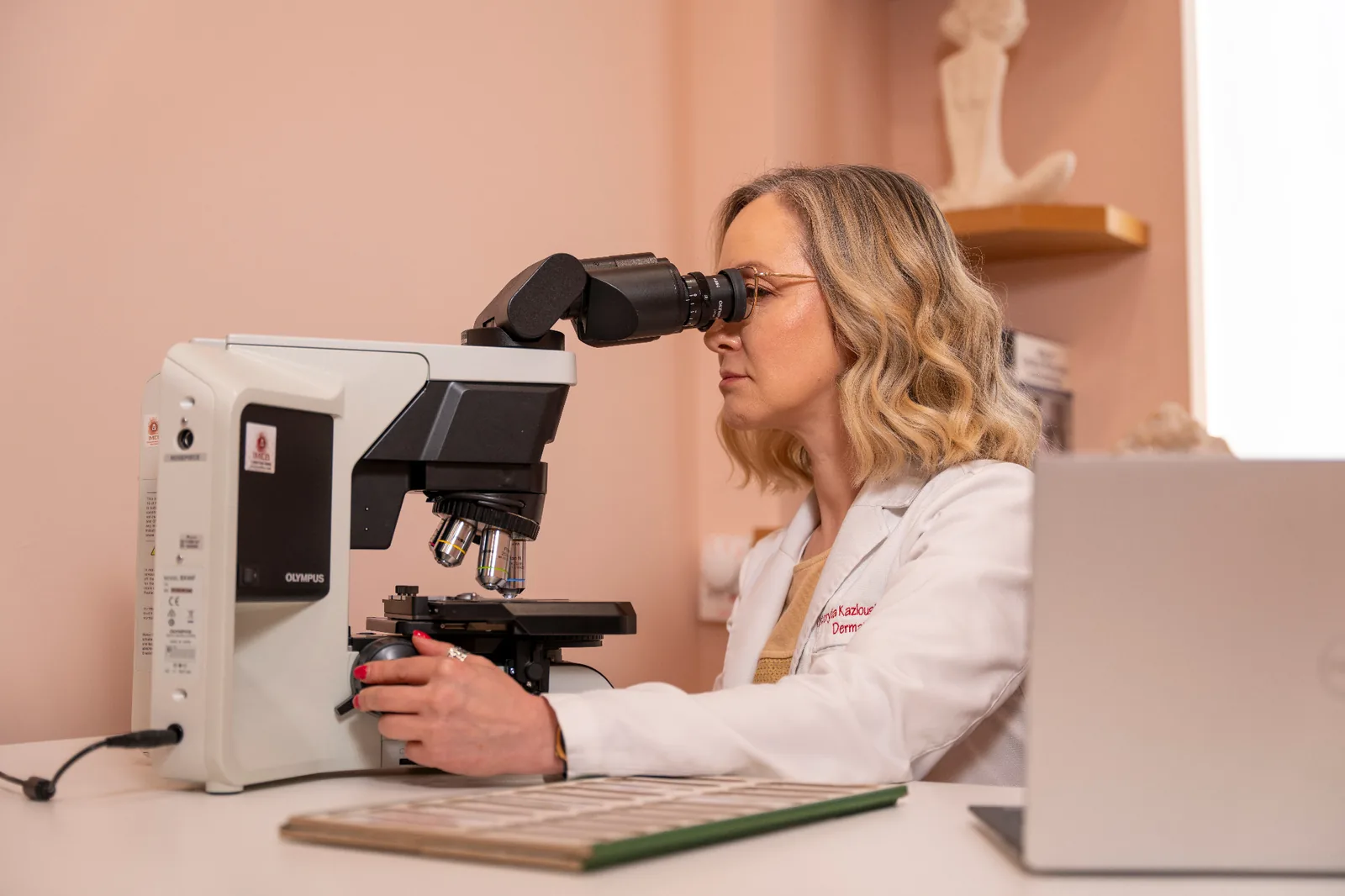 Dermatologist examining a skin sample under the microscope at Dermatology Circle in New York City