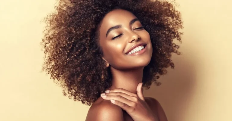 Woman with dark skin and healthy natural hair illustrating dermatologic care for skin of color.